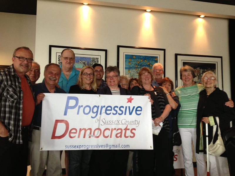 Members of the Progressive Democrats display the group’s logo at the June 3 meeting. Shown (l-r) are Mitch Crane, Peter Schott, Ray Sander, Tom O’Hagan, Claire Snyder-Hall, Will O’Regan, Marie Mayor, Anne Pikolas, Sheryl Swed, Cheryl Fruchtman, Dick Byrne, Connie Jones, Joanne Cabry and Dorothy Brecher SOURCE SUBMITTED